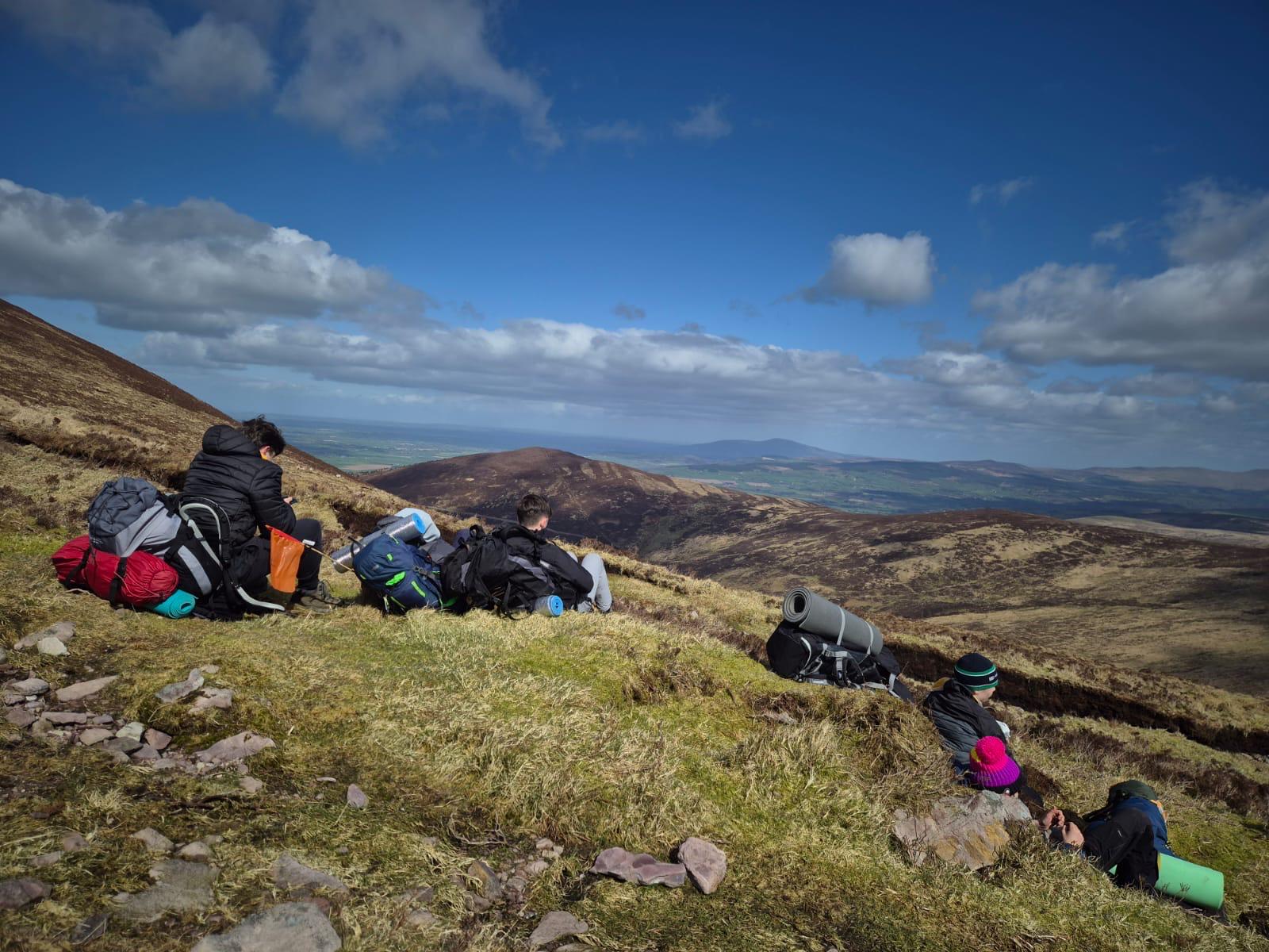 Rucksacks resting on a mountainside, with a view across the hills